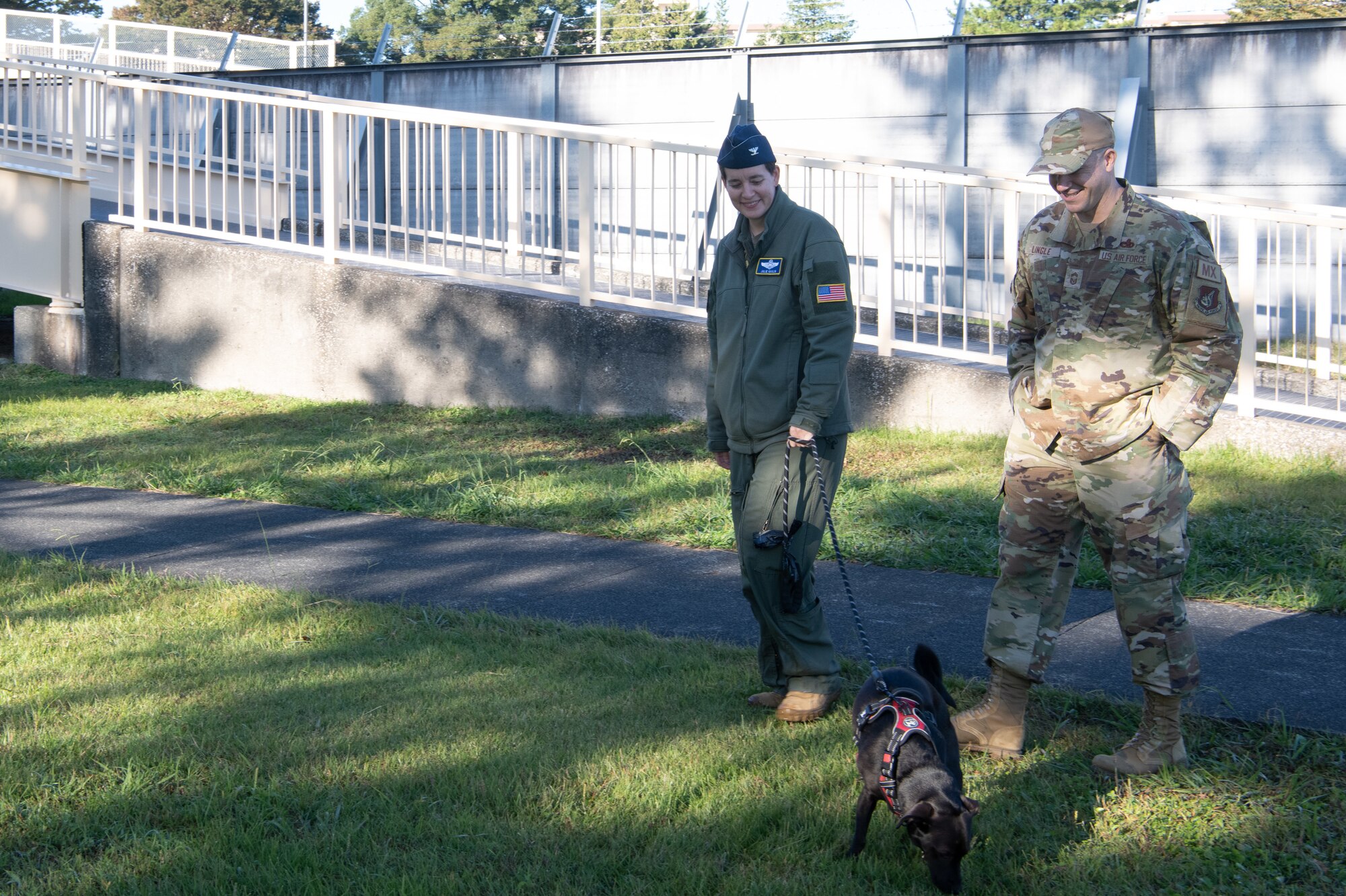 Two command members smile at dog