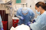 Image of two Airmen treating a patient.