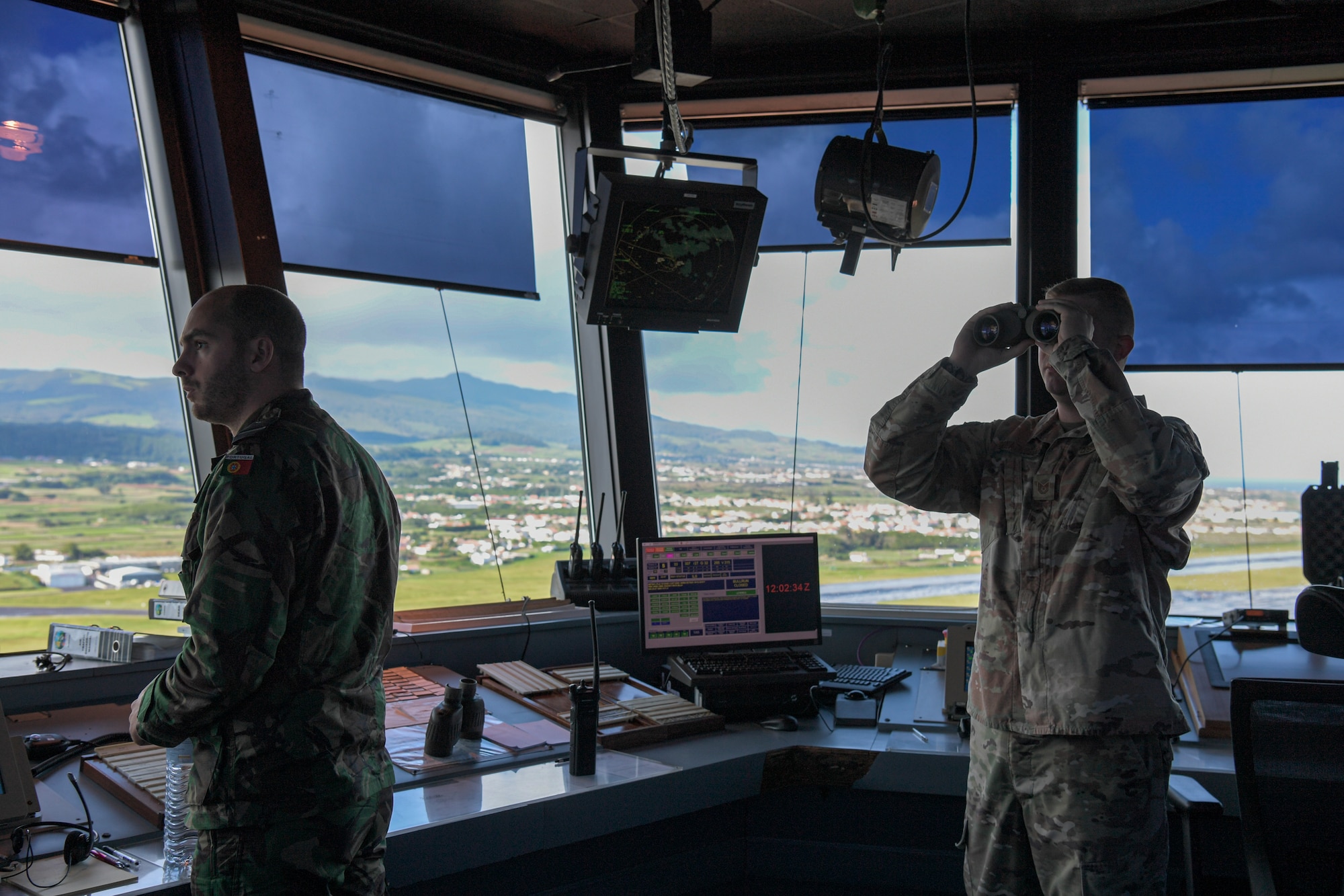 two men look for planes in a tower