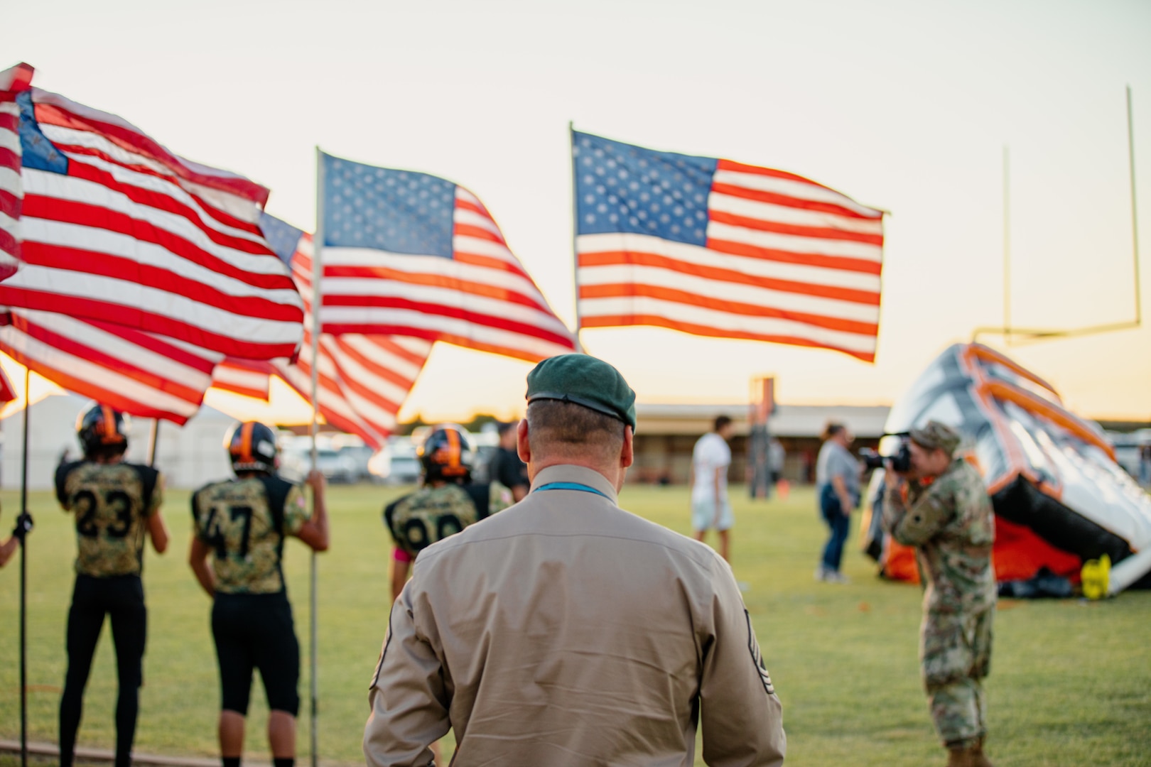 Master Sgt. Earl Plumlee, a Medal of Honor recipient, watches the Merritt High School football team take the field for the playing of the National Anthem in Merritt, Oklahoma, Oct. 21, 2022. Plumlee, a native Oklahoman, toured his home state Oct. 18-22. During his visit, Plumlee spoke to the team before the game, and encouraged the team to play without regrets. (Oklahoma National Guard photo by Spc. Haden Tolbert)