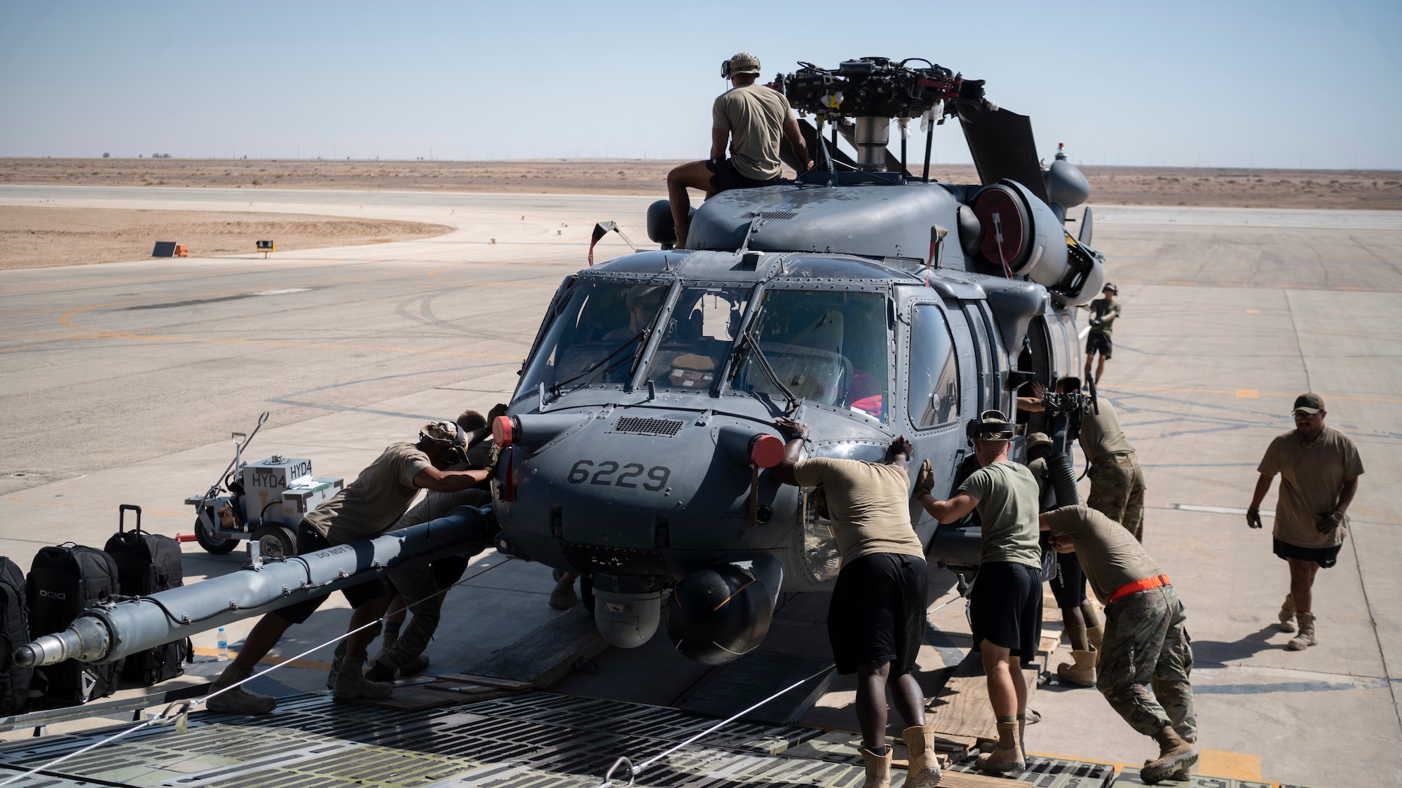 Airmen from the 1st Expeditionary Rescue Group and the 60th Air Mobility Wing, Travis Air Force Base, Calif., unload an HH-60 Pave Hawk helicopter from a C-5M Galaxy at an undisclosed location in Southwest Asia, Oct. 11, 2022. The primary mission of the Pave Hawk is to conduct personnel recovery operations into hostile environments to recover isolated personnel during war. (U.S. Air Force photo by Tech. Sgt. Jeffery Foster)