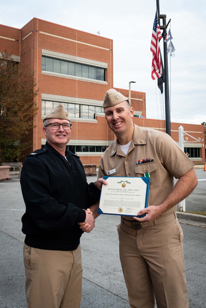 Lt. j.g. Adam Myers receives the Navy and Marine Corps Commendation Medal for his service as Department Head, Material Management.