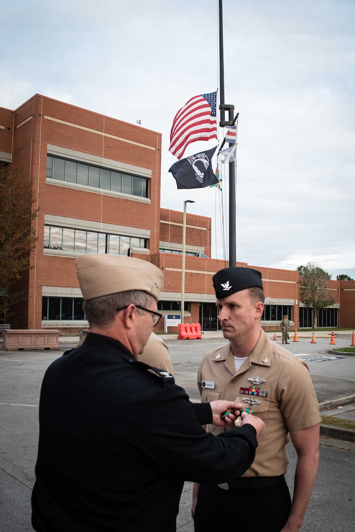 Hospital Corpsman Third Class Justin Chandler receives the Navy and Marine Corps Achievement Medal for his service as a Hospital Corpsman aboard the clinic.