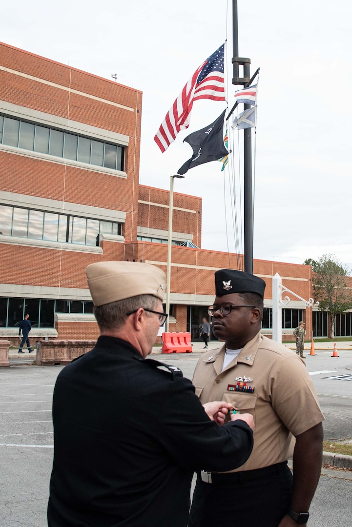 Retail Specialist Second Class Davise Angevine receives the Navy and Marine Corps Achievement Medal for his service as a Retail Specialist aboard the clinic.