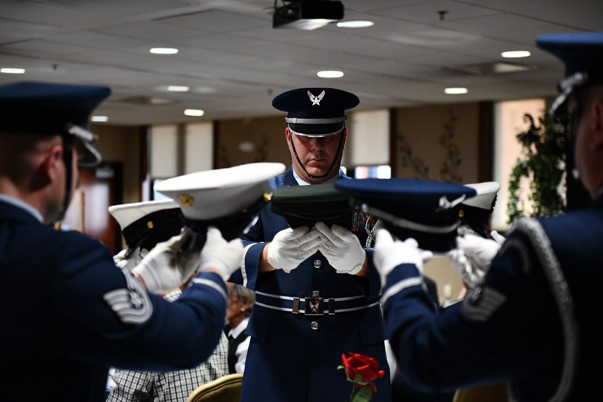 Members of the 910th Airlift Wing's color guard place hats representing the U.S. branches of military service during a missing man table ceremony at a chief induction ceremony at Youngstown Air Reserve Station, Ohio, Oct. 15, 2022.