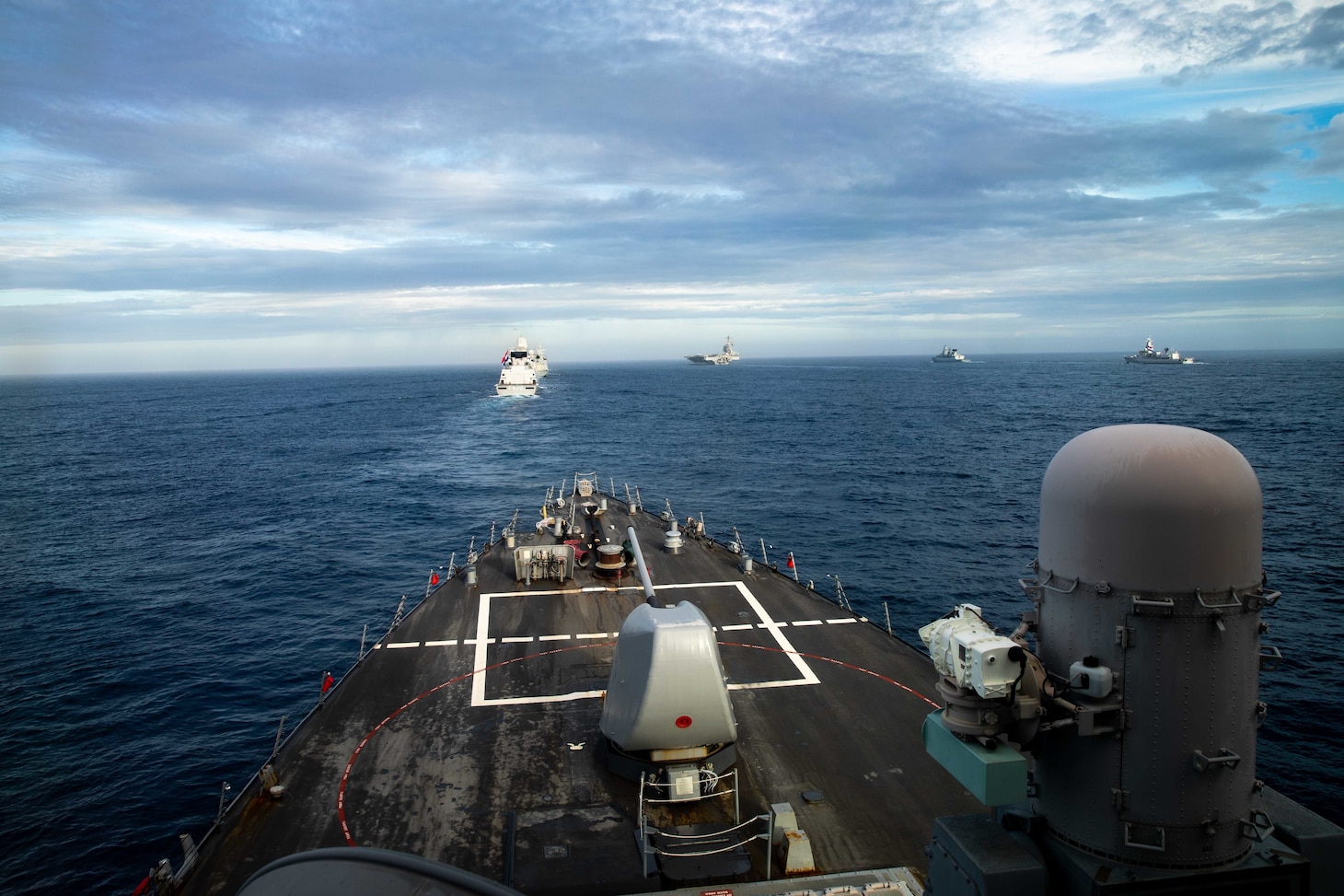 The Arleigh Burke-class guided-missile destroyer USS Ramage (DDG 61), foreground, steams in formation with the Gerald R. Ford Carrier Strike Group and other coalition warships during a formation transit, Oct. 25, 2022.