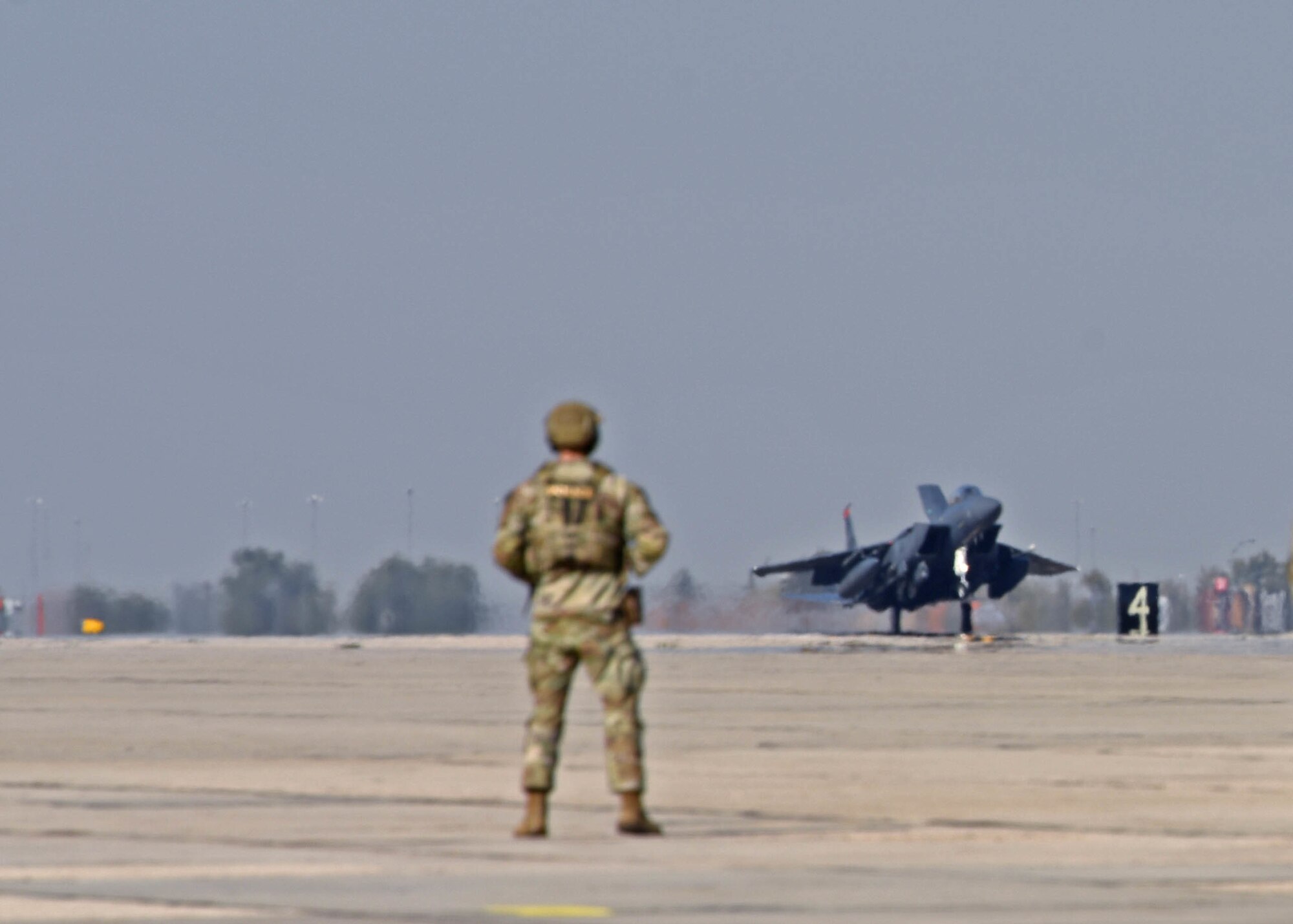 A U.S. Airman with the 366th Security Forces Squadron watches an F-15E Strike Eagle aircraft land for special refueling operations at Gowen Field, Boise, Idaho, Oct. 20, 2022. Special fueling operations were conducted by the 62d Airlift Wing’s C-17 Globemaster III aircraft and the 366th Fighter Wing’s F-15 as part of Exercise Rainier War 22B. (U.S. Air Force photo by Staff Sgt. Zoe Thacker)