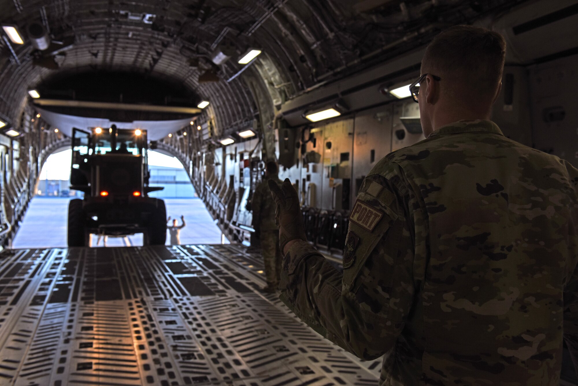 U.S. Air Force Tech. Sgt. Daniel Lackey, aerial porter with the 62d Aerial Port Squadron, guides a forklift onto a C-17 Globemaster III aircraft during Exercise Rainier War 22B at Mountain Home Air Force Base, Idaho, Oct. 19, 2022. Rainier War is a semi-annual exercise designed to demonstrate the 62d Airlift Wing, 627th Air Base Group and 446th Airlift Wing’s ability to generate, employ and sustain operations. (U.S. Air Force photo by Staff Sgt. Zoe Thacker)