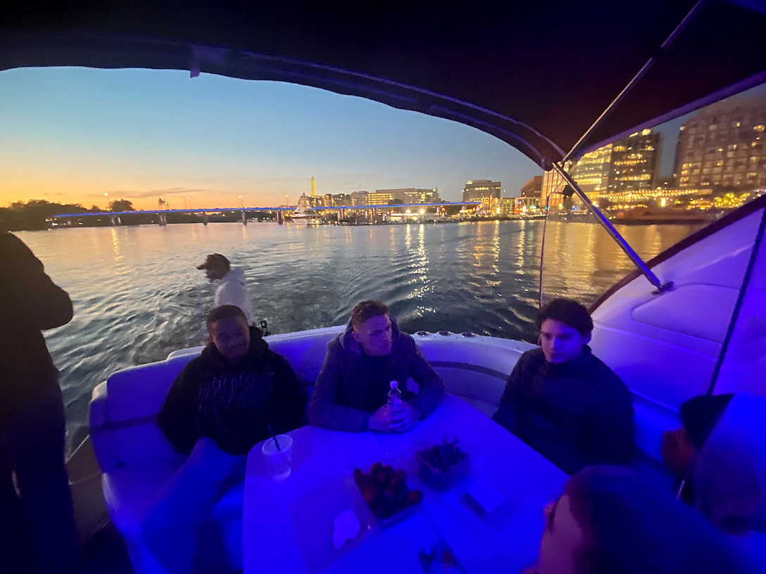 Participants relax as the sun sets behind them during the cruise.