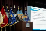 Female at podium presenting PowerPoint slide