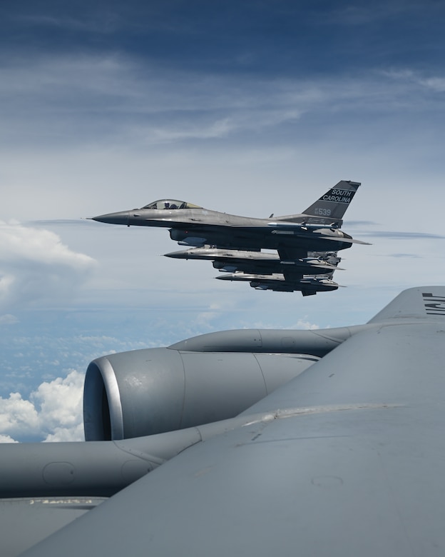 An aircraft is seen in flight from the wing of another flying in formation.