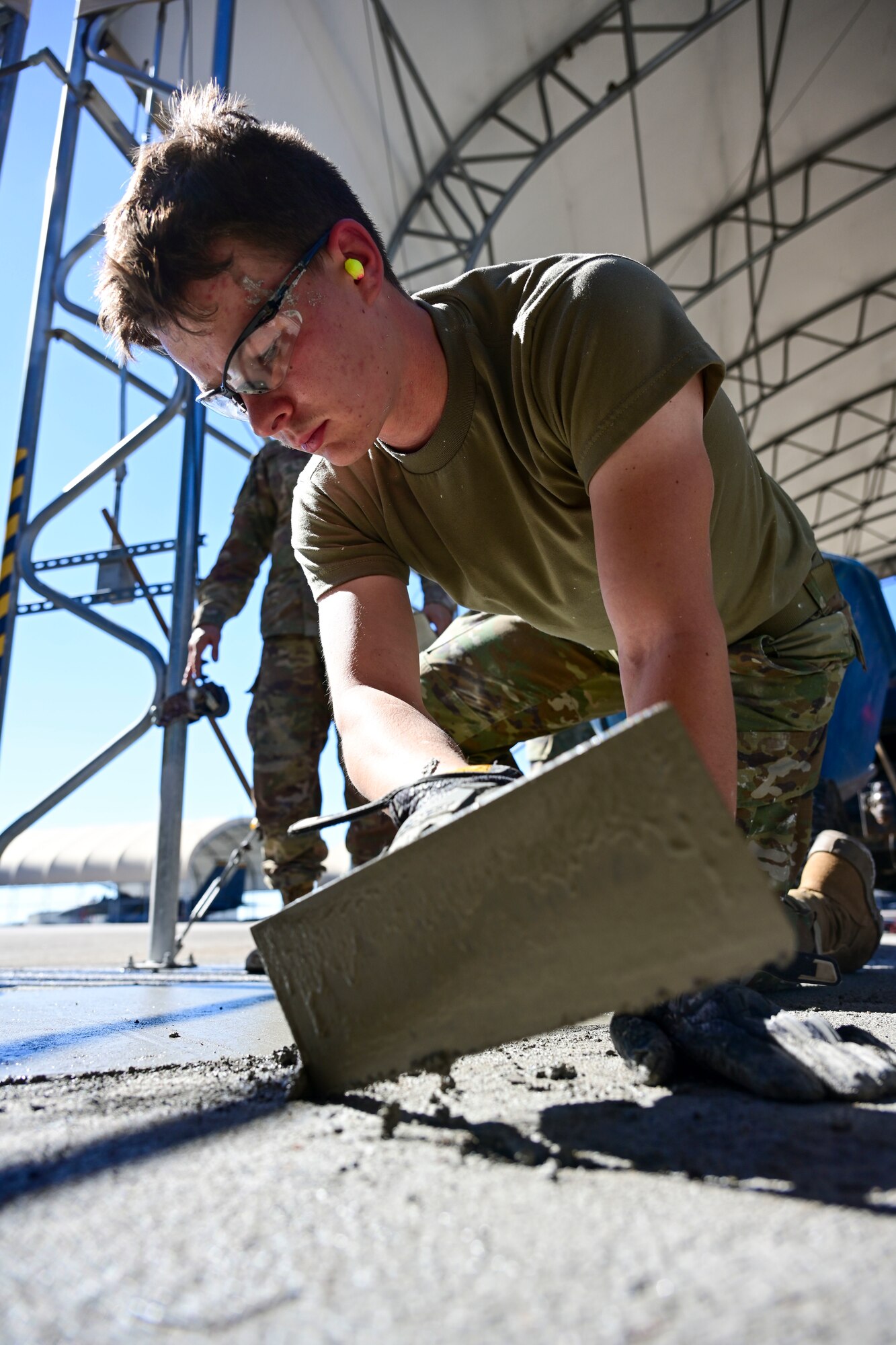 Airman 1st Class Jacob Shelton, 4th Civil Engineer Squadron pavement and equipment technician, levels a patch of concrete at Seymour Johnson Air Force Base, North Carolina, Oct. 26, 2022. Concrete is formed through a chemical reaction called hydration that crystallizes and hardens as water mixes with cement. (U.S. Air Force photo by Senior Airman Kevin Holloway)