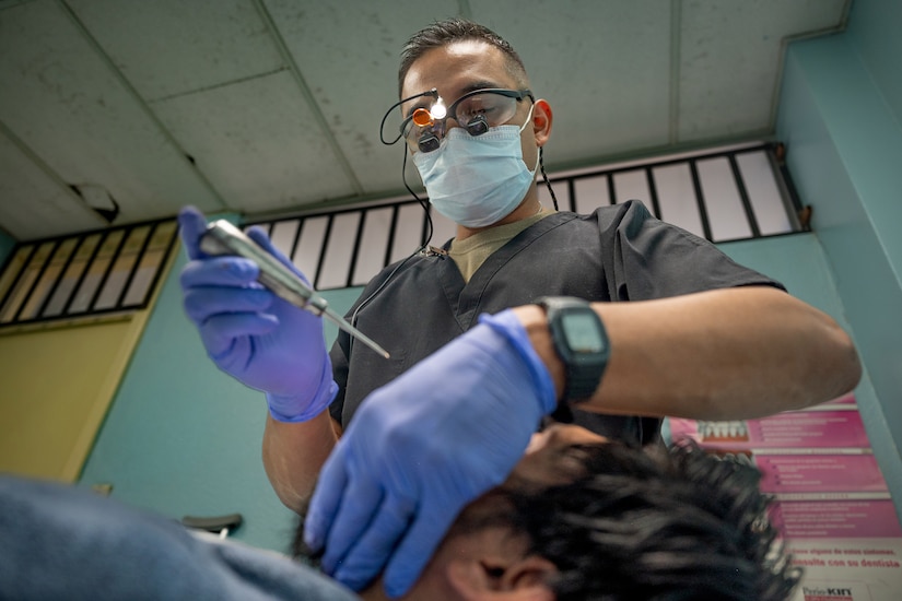 A dentist performs dental work on a patient.