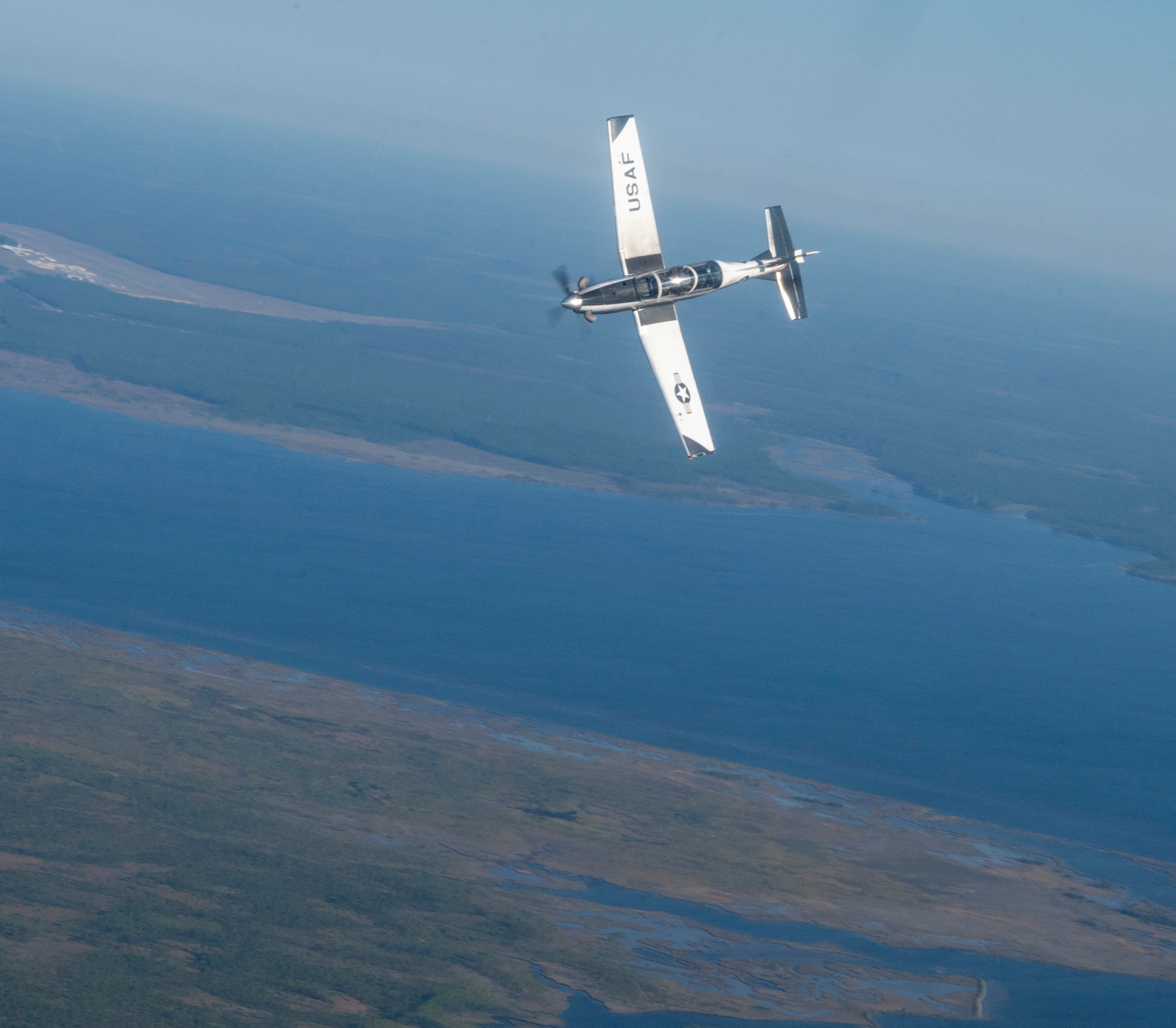 A T-6 Texan II turns in the skies of Florida as part of Ambush Florida on Oct. 14, 2022. Ambush Florida is a mission where pilots from the 85th Flying Training Squadron fly to a different region of the U.S. and "ambush" other bases, helping pilots gain experience in long distance flights. (U.S. Air Force photo by Senior Airman Nicholas Larsen.)