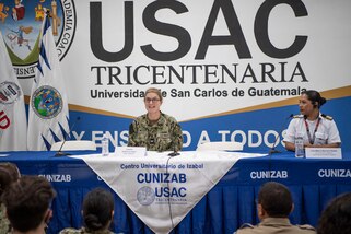 Capt. Kathryn Elliott, commanding officer of the Medical Treatment Facility aboard the Military Sealift Command hospital ship USNS Comfort (T-AH 20), left, and Clara Maria Barrera Ralda, the first female pilot of the Naval Command in Guatemala, speak to a gathering at the Centro Universitario de Izabal during a women, peace and security event, Oct. 27, 2022.