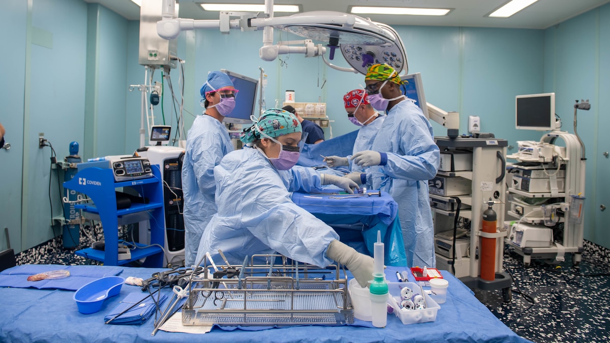 221027-N-DF135-1161 PUERTO BARRIOS, Guatemala (Oct. 27, 2022) – Hospital Corpsman 3rd Class Monica Martinez, from Edinburg, Texas, front, reaches for surgical instruments during a laparoscopic cholecystectomy aboard the hospital ship USNS Comfort (T-AH 20), Oct. 27, 2022. Comfort is deployed to U.S. 4th Fleet in support of Continuing Promise 2022, a humanitarian assistance and goodwill mission conducting direct medical care, expeditionary veterinary care, and subject matter expert exchanges with five partner nations in the Caribbean, Central and South America. (U.S. Navy photo by Mass Communication Specialist Seaman Deven Fernandez)