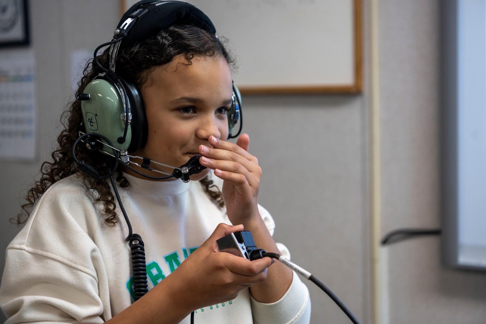Student talks into a microphone headset connected by a wire.