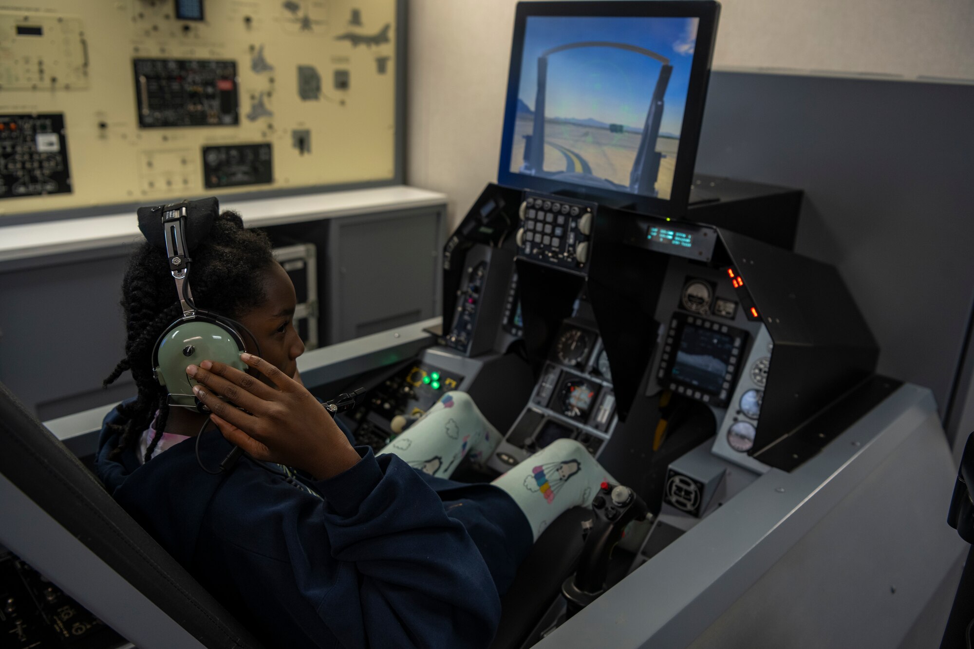 Student communicates through headset connected by a wire to another student.