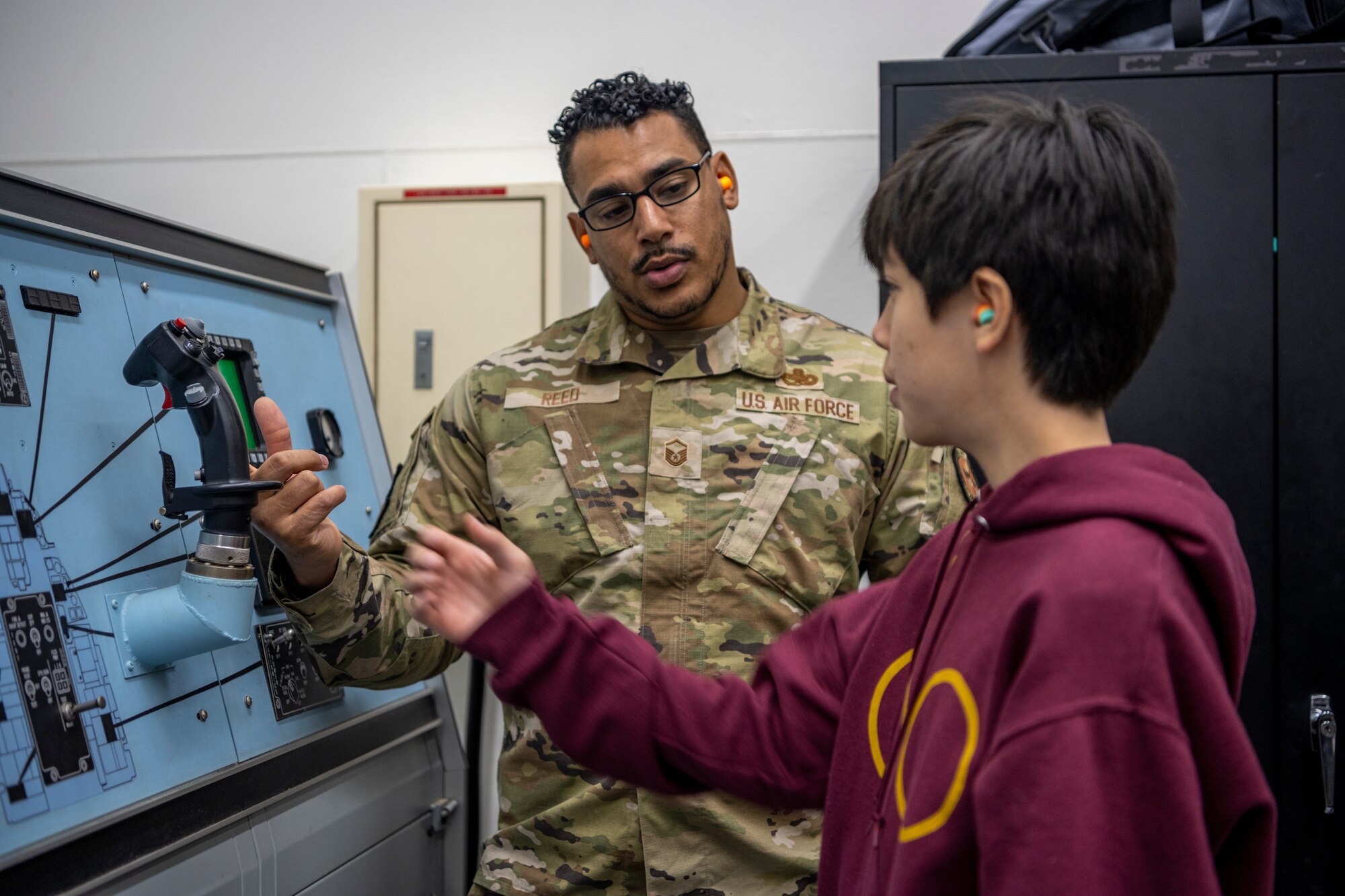 Airman explains how flight stick works while student is about to grab it.