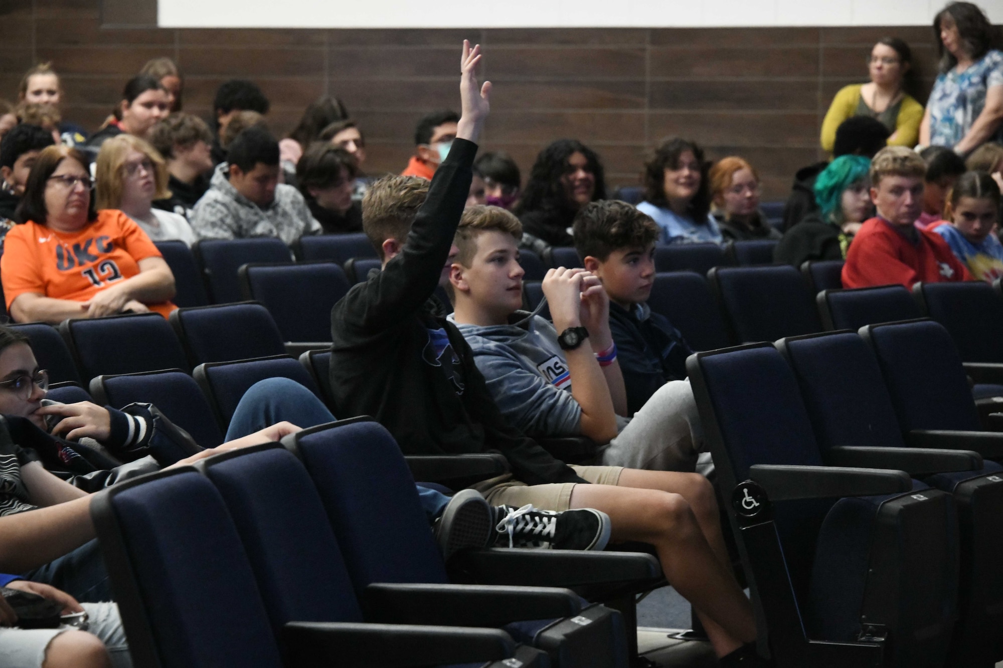 A student from Altus High School (AHS) asks a question during a Red Ribbon Week presentation at AHS, Oklahoma, Oct. 26, 2022. Red Ribbon Week is celebrated in the last week of October and is a time to spread awareness of the killing and destruction caused by drugs in America. (U.S. Air Force photo by Airman 1st Class Miyah Gray)