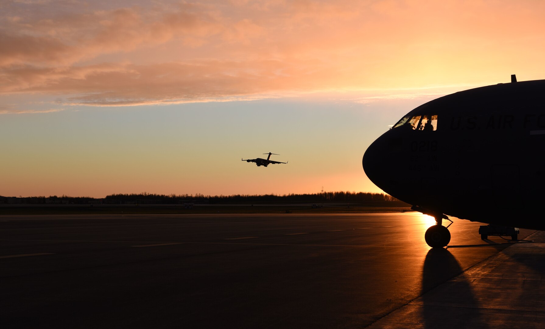 A C-17 Globemaster III lands on the runway after an evening sortie