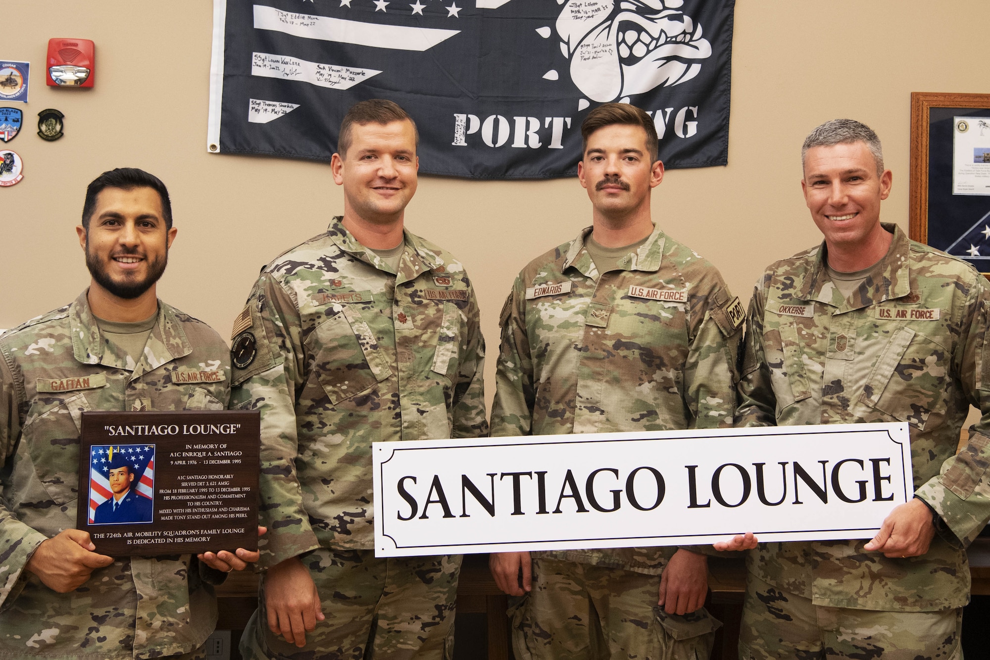 U.S. Air Force Airmen assigned to the 724th Air Mobility Squadron pose for a photo with memorial plaques for the late Airman 1st Class Enrique “Tony” Santiago, on Aviano Air Base, Italy, Aug. 18, 2022.