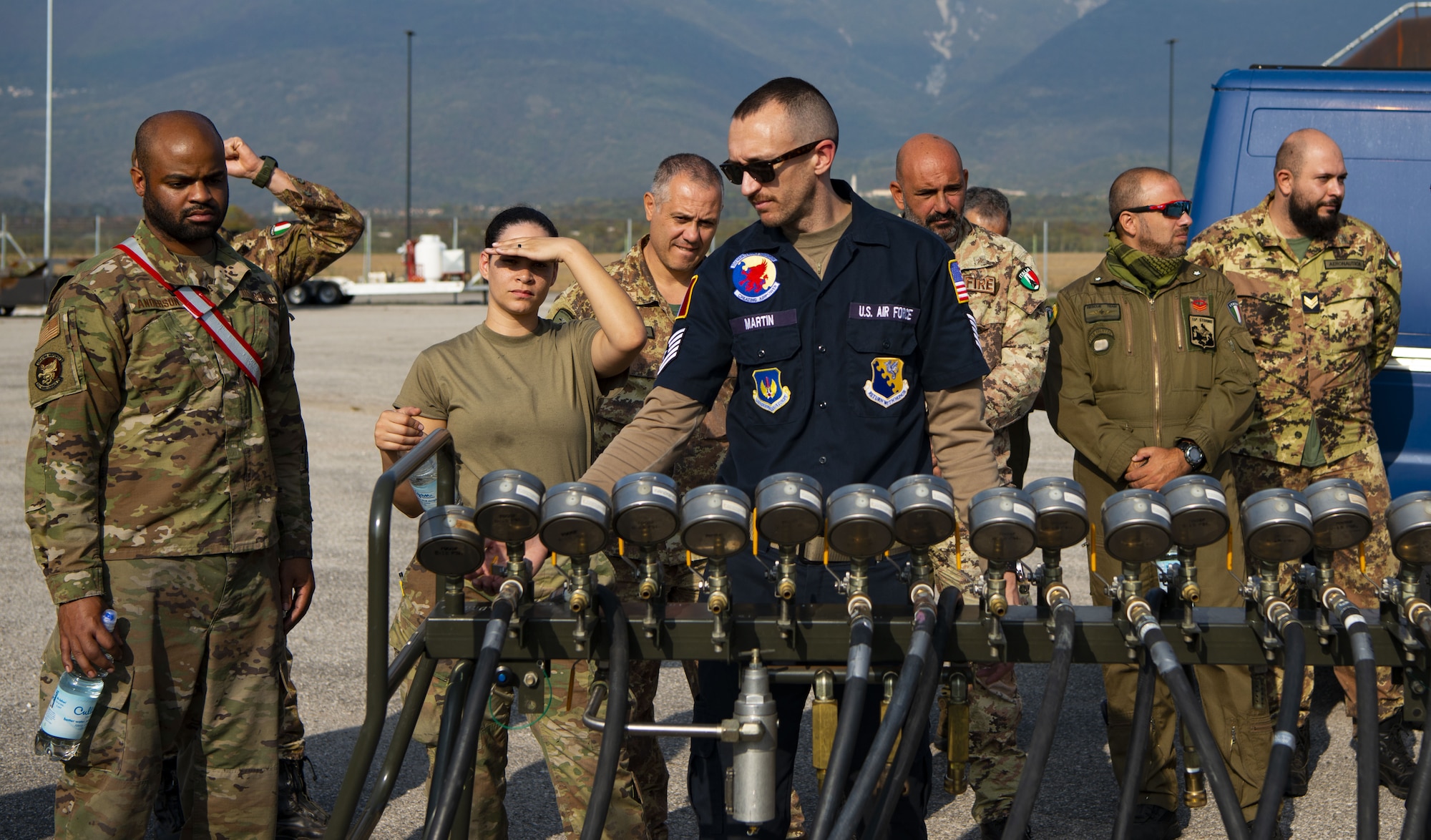 U.S. Airmen and ITAF airmen stand behind an inflation console as they watch a bag lift during a crashed, damaged or disabled aircraft recovery (CDDAR) training at Aviano Air Base, Italy, Oct. 20, 2022. Airmen from Ramstein as well as Spangdahlem Air Force Base in Germany and the Italian air force were involved in the joint training. (U.S. Air Force photo by Airman 1st Class Thomas Calopedis)