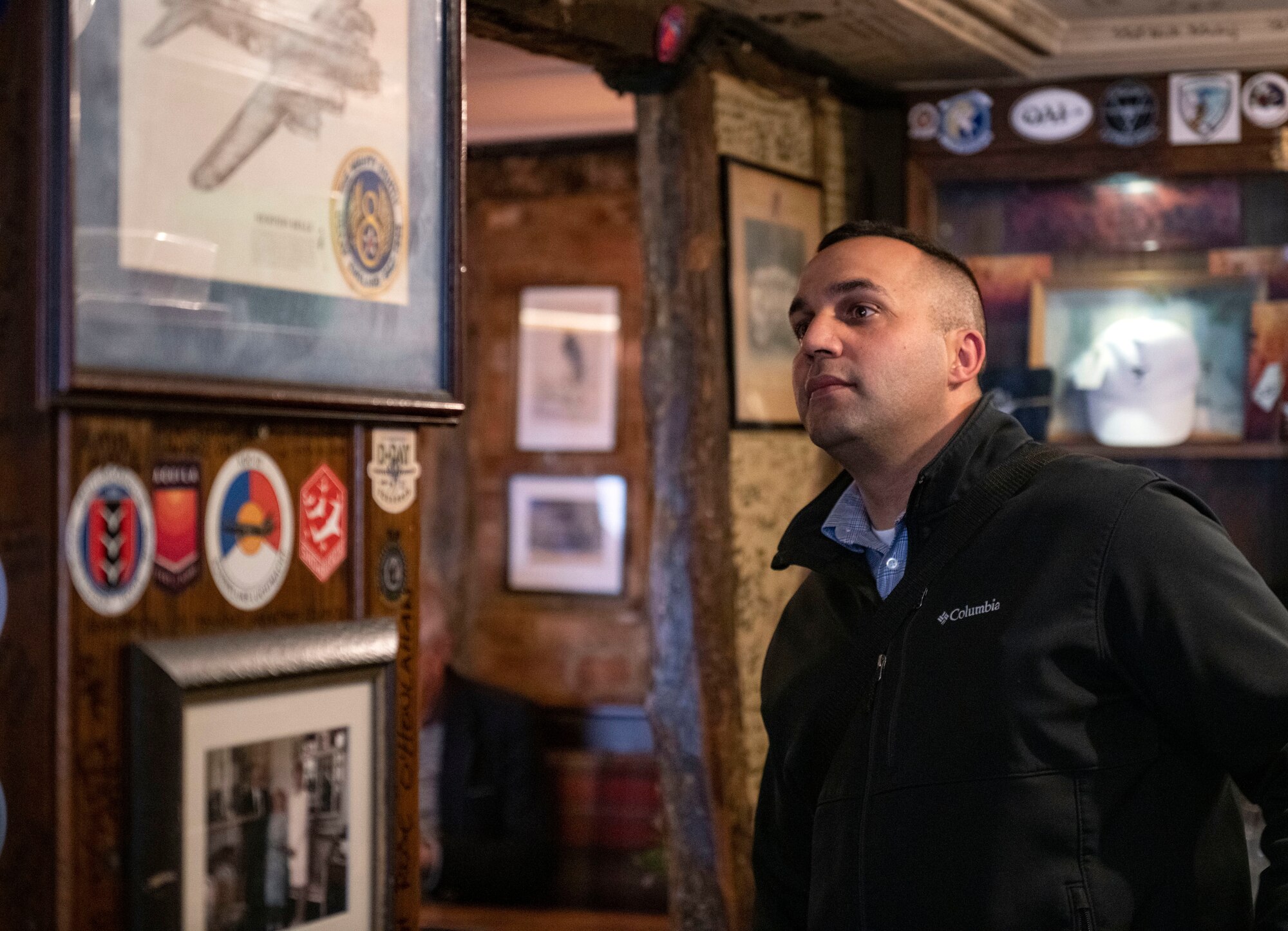 Senior Master Sgt. David Randolph, 422d Security Forces Squadron senior enlisted leader, looks at patches and signatures left by Airmen at the Royal Air Force pub, in Cambridge