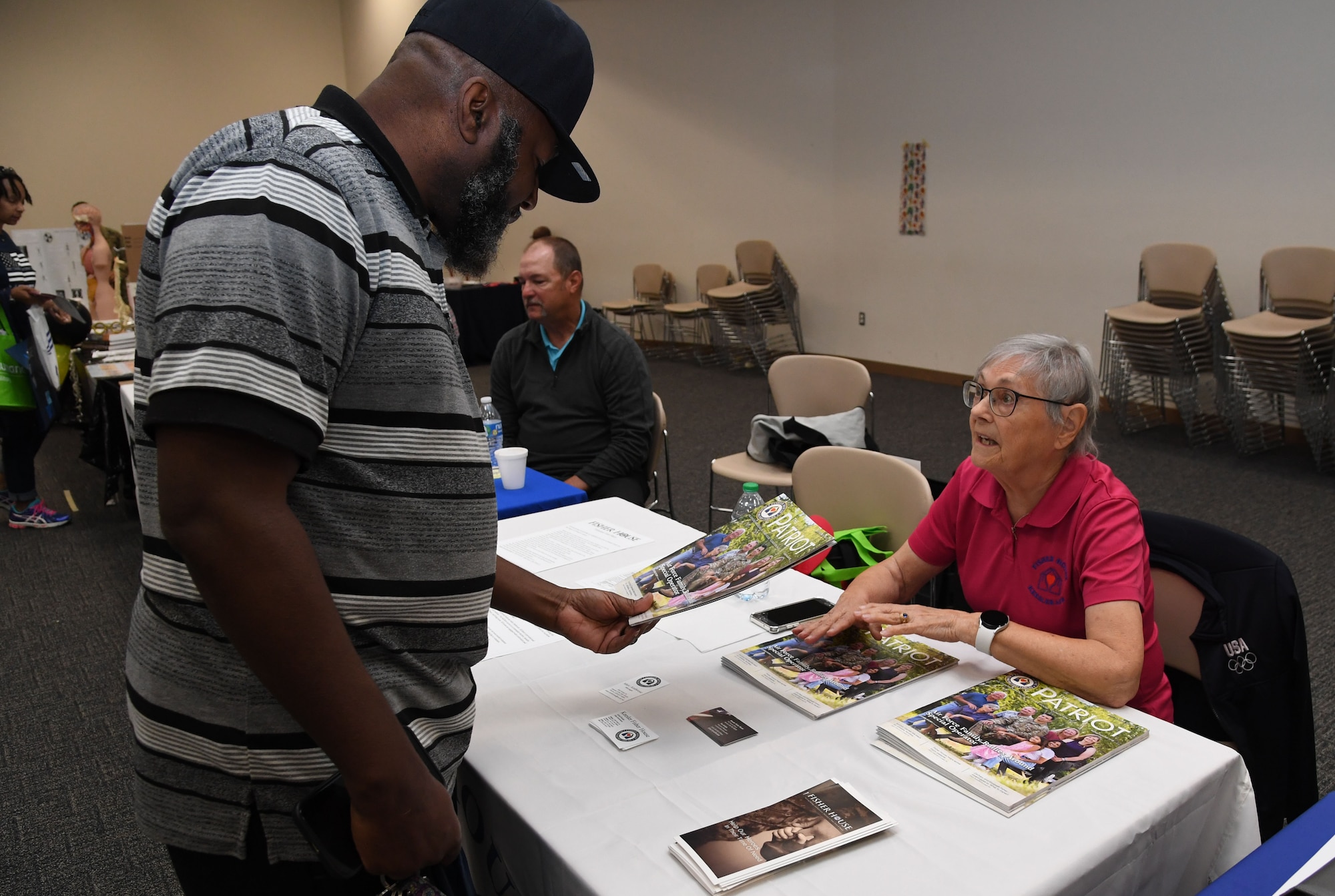 Pat Morris, Fisher House volunteer, provides information to U.S. Army retired Sgt. 1st Class Henry Leonard during Retiree Appreciation Day inside the Roberts Consolidated Aircraft Maintenance Facility at Keesler Air Force Base, Mississippi, Oct. 28, 2022.