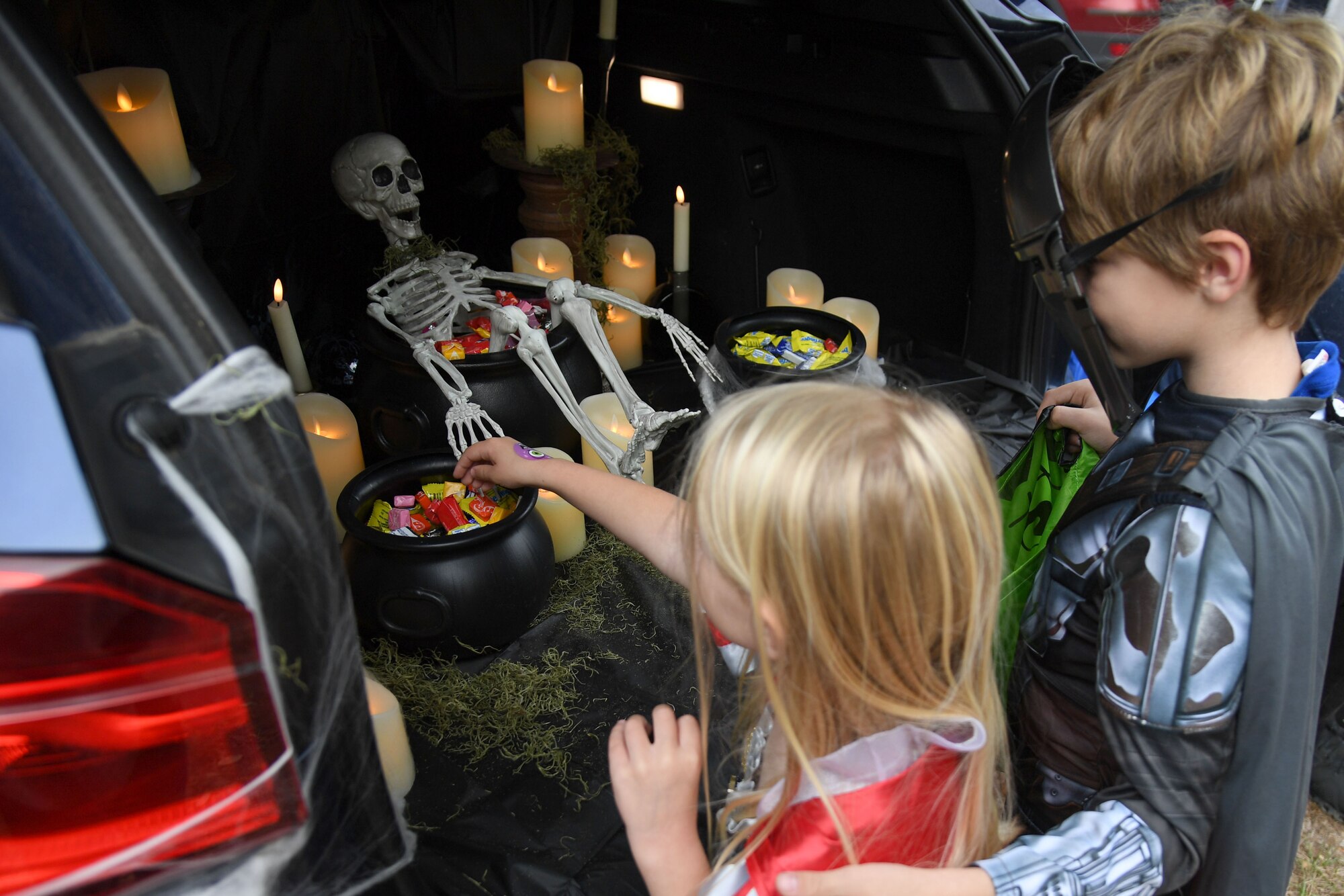 Anabelle and Connor Watson, children of U.S. Air Force Master Sgt. Chad Watson, 334th Training Squadron airfield management superintendent, collect candy during Ghouls in the Park at the marina park at Keesler Air Force Base, Mississippi, Oct. 28, 2022.