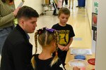 IMAGE: Jacob Barber, a Naval Surface Warfare Center Dahlgren Division scientist, discusses a classroom STEM project on slime with Lewis and Clark Elementary School first graders Starr Minneman and Beckett Fultz during the school’s STEM Fair Oct. 27.