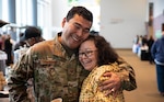 Alaska National Guard Tech. Sgt. Blassi Shoogukwruk, a C-17 Globemaster III crew chief with the 176th Aircraft Maintenance Squadron, hugs his cousin, Patti Oksoktaruk Lillie, during the First Alaskans Institute Elder and Native Youth conference in Anchorage, Alaska, Oct. 18, 2022. The conference gives Alaska Native youth opportunities to meet with elders in their communities and learn how to advocate for themselves and their people as well as connect with others.