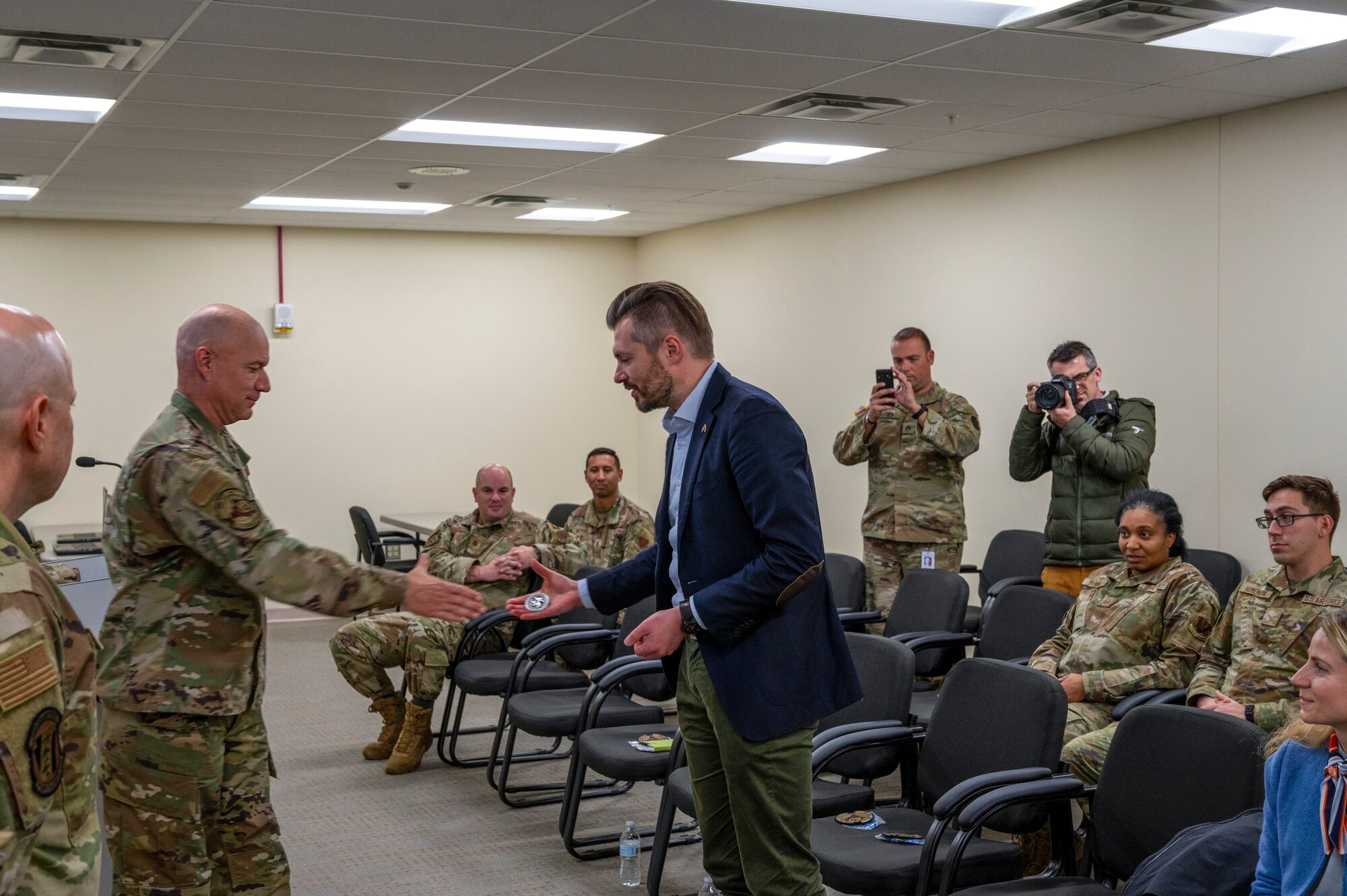A man in uniform accepts a coin from a civilian.