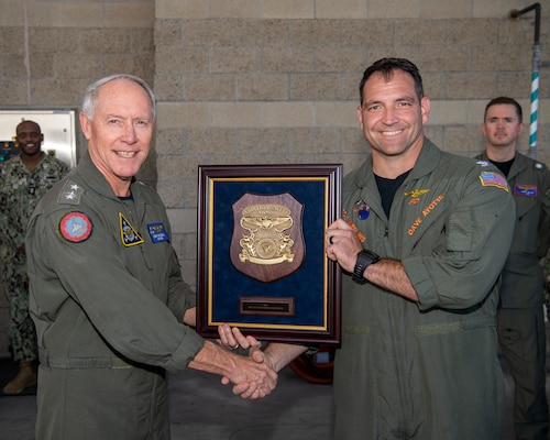 Vice Adm. Kenneth Whitesell, Commander, U.S. Naval Air Forces, left, presents the 2021 Chief of Naval Operations (CNO) Aviation Safety Award to Capt. David Ayotte, commanding officer of the “Merlins” of Helicopter Sea Combat Squadron (HSC) 3, during an award ceremony held aboard Naval Air Station North Island, Oct. 20, 2022