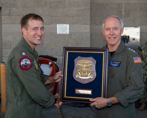 Vice Adm. Kenneth Whitesell, Commander, U.S. Naval Air Forces, right, presents the 2021 Chief of Naval Operations (CNO) Aviation Safety Award to Cmdr. Benjamin Hendricks, commanding officer of the “Black Knights” of Helicopter Sea Combat Squadron (HSC) 4, during an award ceremony held aboard Naval Air Station North Island, Oct. 20, 2022.