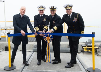 NAVAL BASE KITSAP – BANGOR, Wash. (Oct. 19, 2022) Mr. Peter Fleck, Submarine Development Group 5 facility operations manager, left, Adm. Stuart Munsch, commander, U.S. Naval Forces Europe-Africa, Capt. Gary Montalvo, commodore, Submarine Development Group 5, and Capt. Kevin Pickard, chief of staff, Navy Region Northwest, cut a ribbon during a ceremony for a newly-completed service pier located on Naval Base Kitsap – Bangor, October 19, 2022. The ceremony marked the completion of a major infrastructure project that will support the arrival of fast attack submarines, including the planned change of homeport for the Seawolf-class fast-attack submarines USS Seawolf (SSN 21) and USS Connecticut (SSN 22) from Naval Station Kitsap-Bremerton to Naval Base Kitsap-Bangor. (U.S. Navy photo by Mass Communication Specialist 1st Class Brian G. Reynolds)