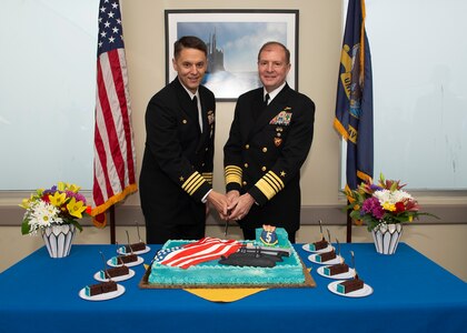 NAVAL BASE KITSAP – BANGOR, Wash. (Oct. 19, 2022) Capt. Gary Montalvo, commodore, Submarine Development Group 5, left, and Adm. Stuart Munsch, commander, U.S. Naval Forces Europe-Africa, cut a cake during a ceremony for a newly-completed service pier located on Naval Base Kitsap – Bangor, October 19, 2022. The ceremony marked the completion of a major infrastructure project that will support the arrival of fast attack submarines, including the planned change of homeport for the Seawolf-class fast-attack submarines USS Seawolf (SSN 21) and USS Connecticut (SSN 22) from Naval Station Kitsap-Bremerton to Naval Base Kitsap-Bangor. (U.S. Navy photo by Mass Communication Specialist 1st Class Brian G. Reynolds)