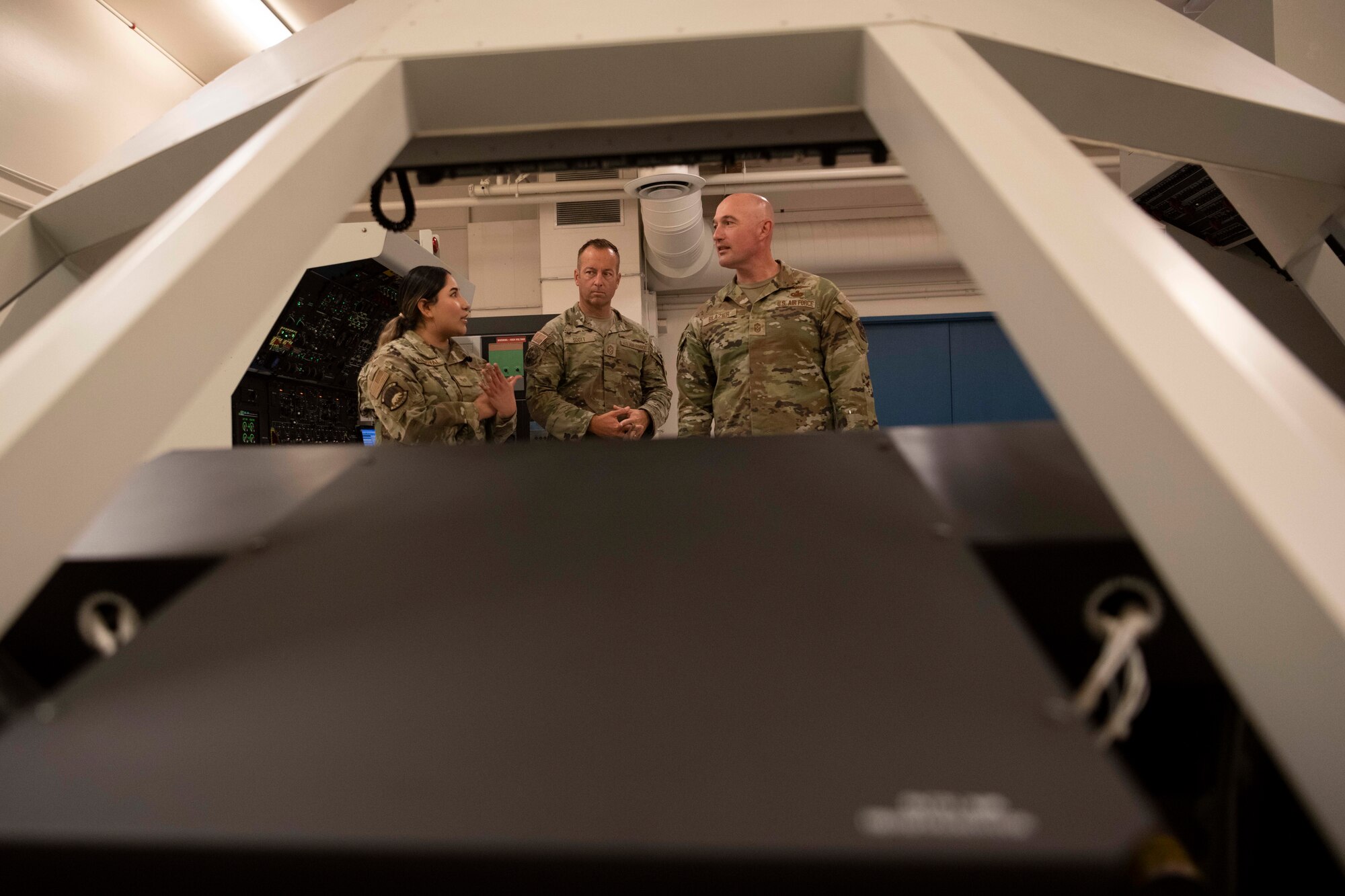 Airmen talk inside of an aircraft simulator