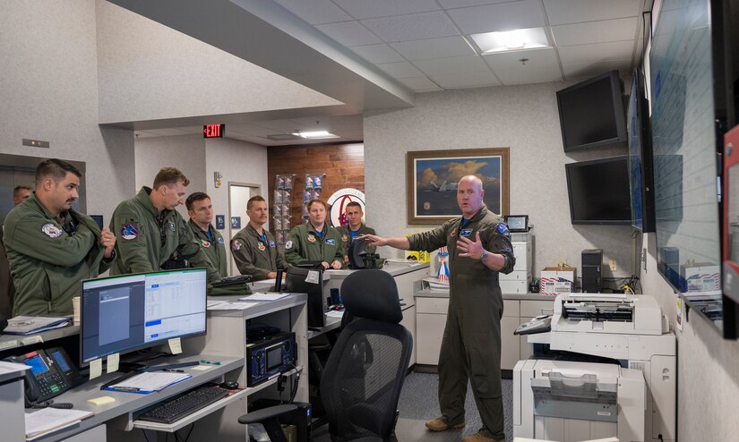 Lt. Col. Andrew, 94th Fighter Squadron director of operations, briefs participants on their assigned roles during the Battle of Britain commemoration at the 94th FS, Joint Base Langley-Eustis, Virginia, Oct. 21, 2022. F-22 Raptors from the 94th FS replicated the roles of British aircraft from the Fighter Command that defended the British coast during the conflict, that occurred from June 10, 1940 to Oct. 31, 1940, and was a significant turning point for Allied forces in World War II. (U.S. Air Force photo by Tech. Sgt. Matthew Coleman-Foster)