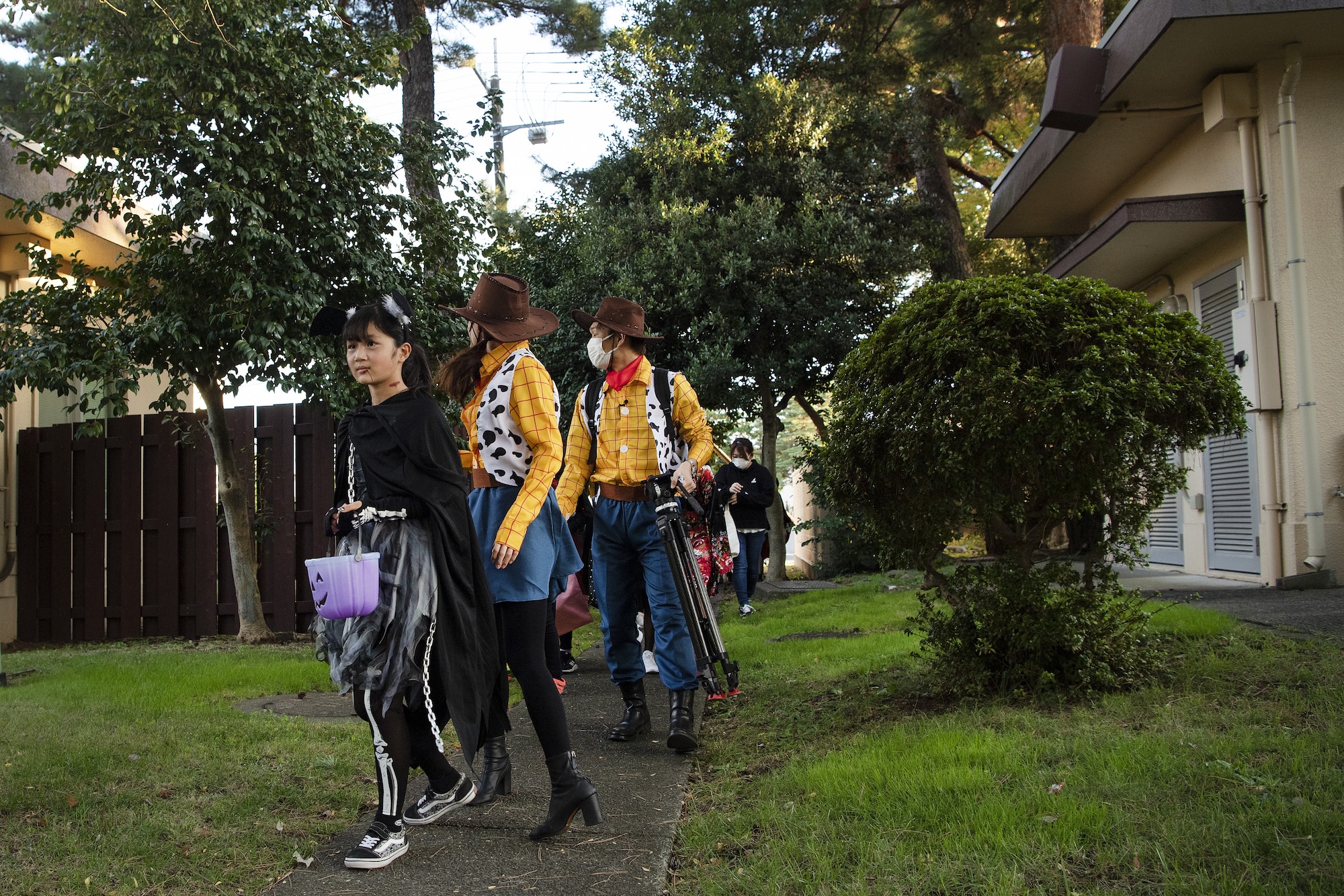 Saaya Kobayashi, trick-or-treater, leads members of the Japanese community into base housing for trick-or-treating at Yokota Air Base, Japan, Oct. 29, 2022. This year, members of the base were able to sponsor up to ten visitors onto base for trick-or-treating. Activities like trick-or-treating give Yokota personnel, families, and friends on and off base an opportunity to celebrate the holiday, enjoy an evening of Halloween activites, and strengthen ties between the U.S. and Japan. (U.S. Air Force photo by Tech. Sgt. Christopher Hubenthal)