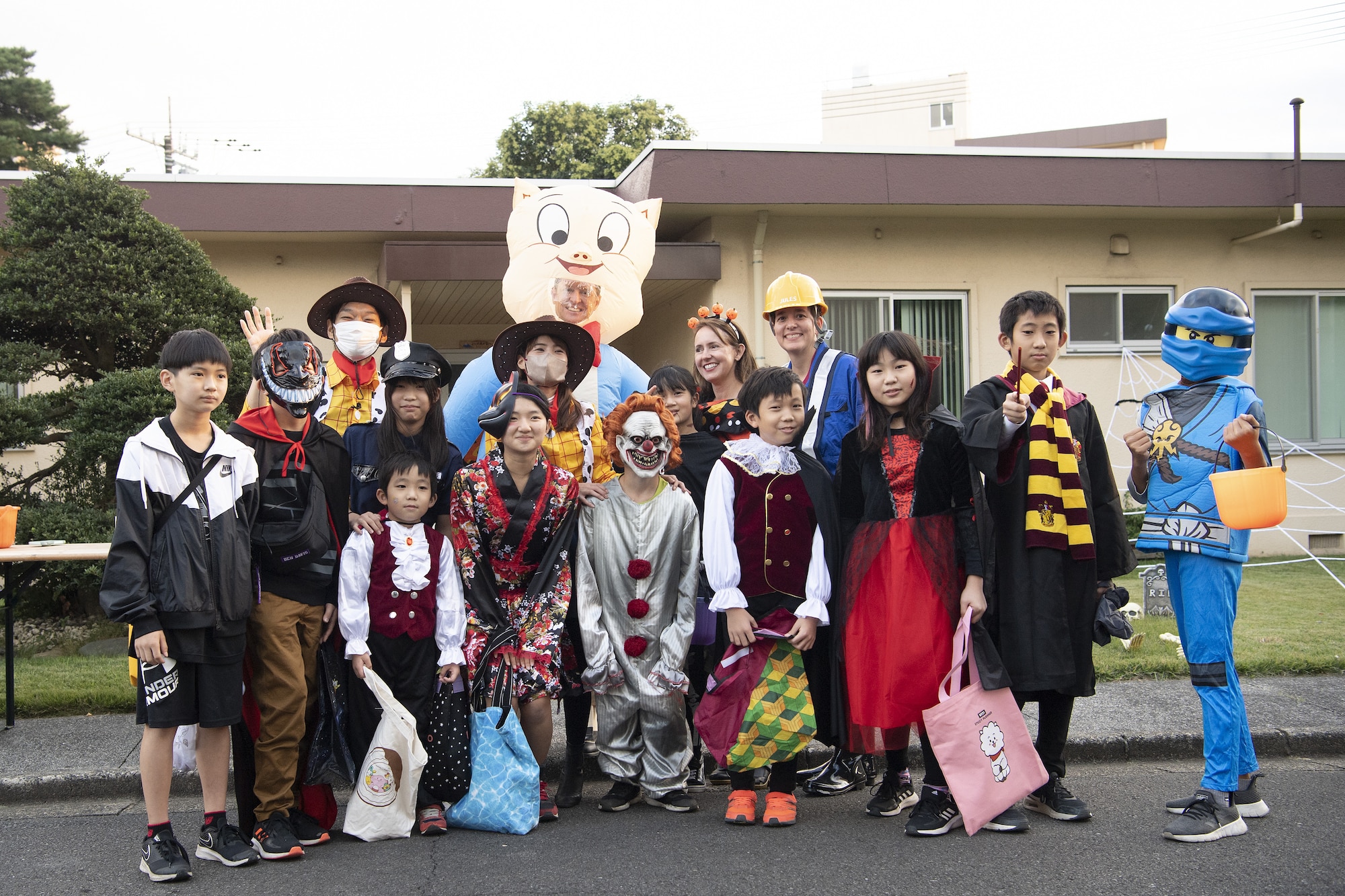 Members of the 374th Airlift Wing and Japanese community pose for a photo during trick-or-treating at Yokota Air Base, Japan, Oct. 29, 2022. This year, members of the base were able to sponsor up to ten visitors onto base for trick-or-treating. Activities like trick-or-treating help build mutual understanding of the distinctive cultures of the U.S. and Japan, deepen friendships, and further strengthen the critical relationship Yokota has with its surrounding communities. (U.S. Air Force photo by Tech. Sgt. Christopher Hubenthal)