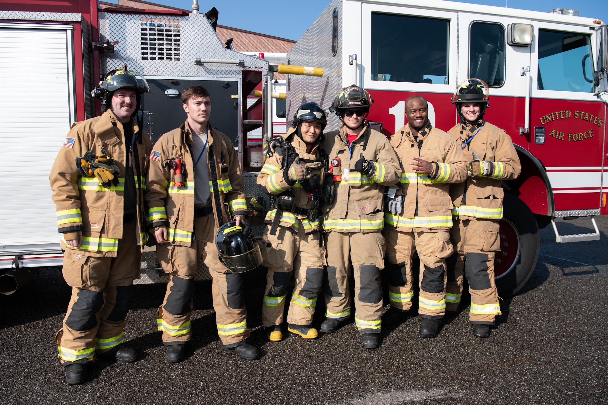 U.S. Air Force Airmen from the 8th Civil Engineer Squadron fire services flight, takes a photo with Gunsan City Firefighter Seun Wan, at Wolmyung Stadium, Gunsan City, Republic of Korea, Oct. 28, 2022. Training with the local fire department ensures both the Gunsan City Fire Department and Kunsan Air Base firefighters can support and work fluidly in an emergency. (U.S. Air Force photo by Staff Sgt. Sadie Colbert)