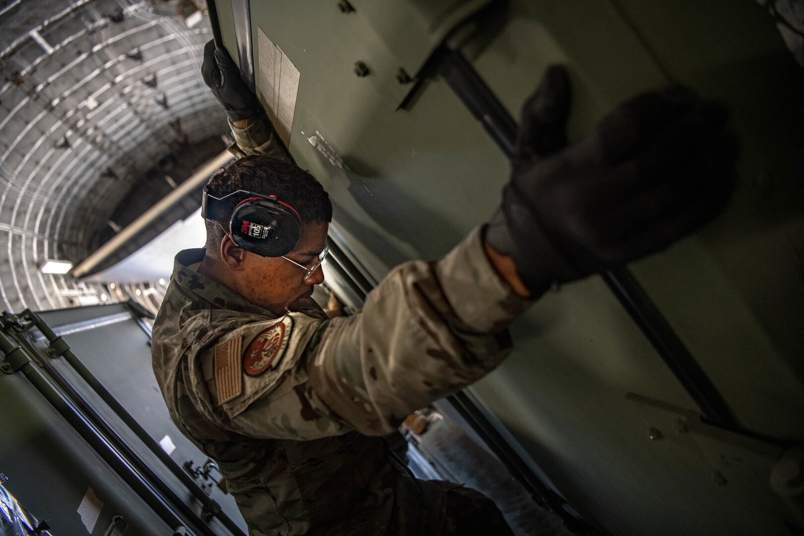 an airman loads a container unit onto a C-17 Globemaster III