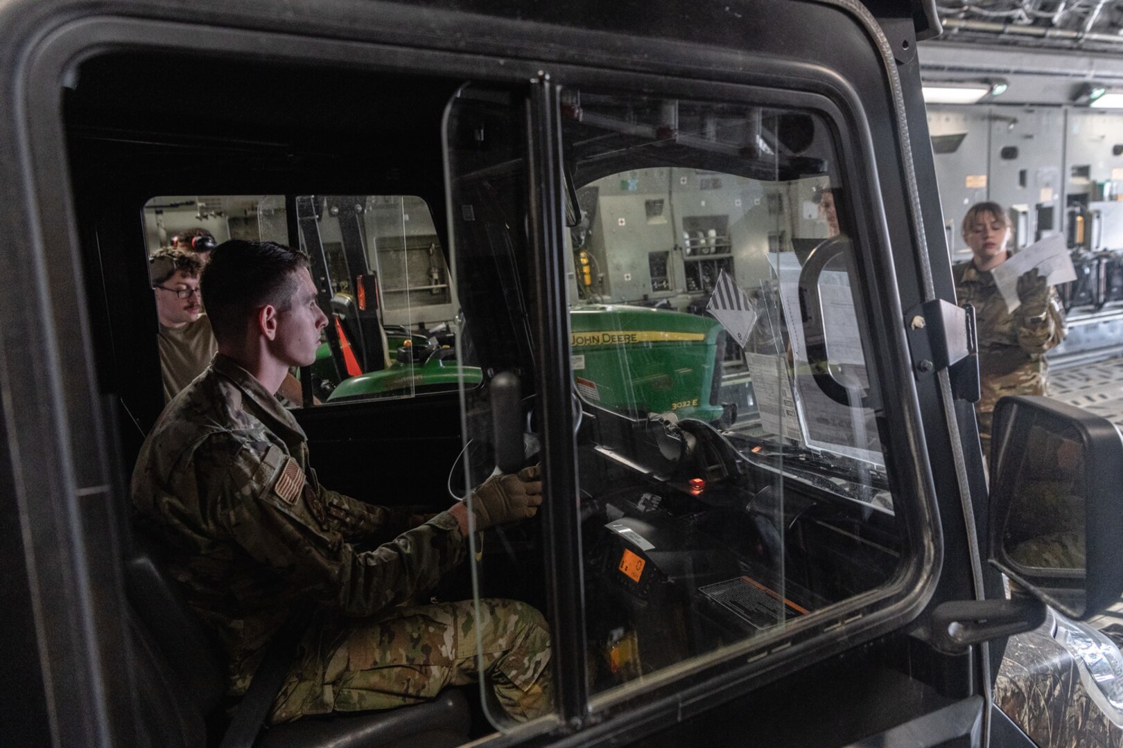 an Airman loads an all-terrain vehicle onto a C-17 Globemaster III