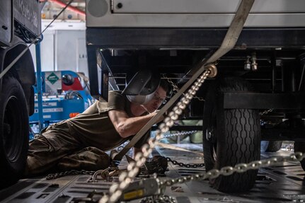 an Airman secures cargo with a chain on a C-17 Globemaster III