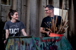 Two people talking while carrying construction debris.