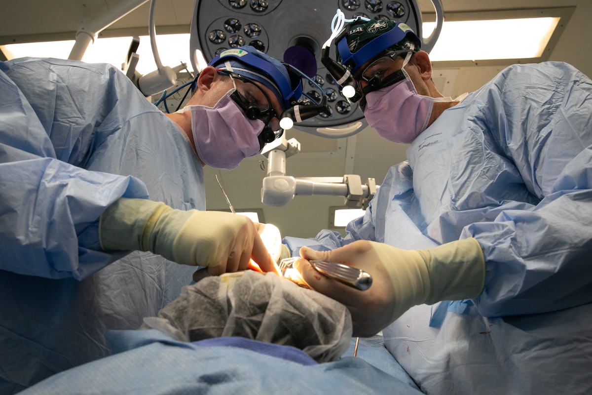 Lt. Cmdr. James McLean, left, and Cmdr. Michael Eliason, perform a rhinoscopy aboard the Military Sealift Command hospital ship USNS Comfort (T-AH 20).