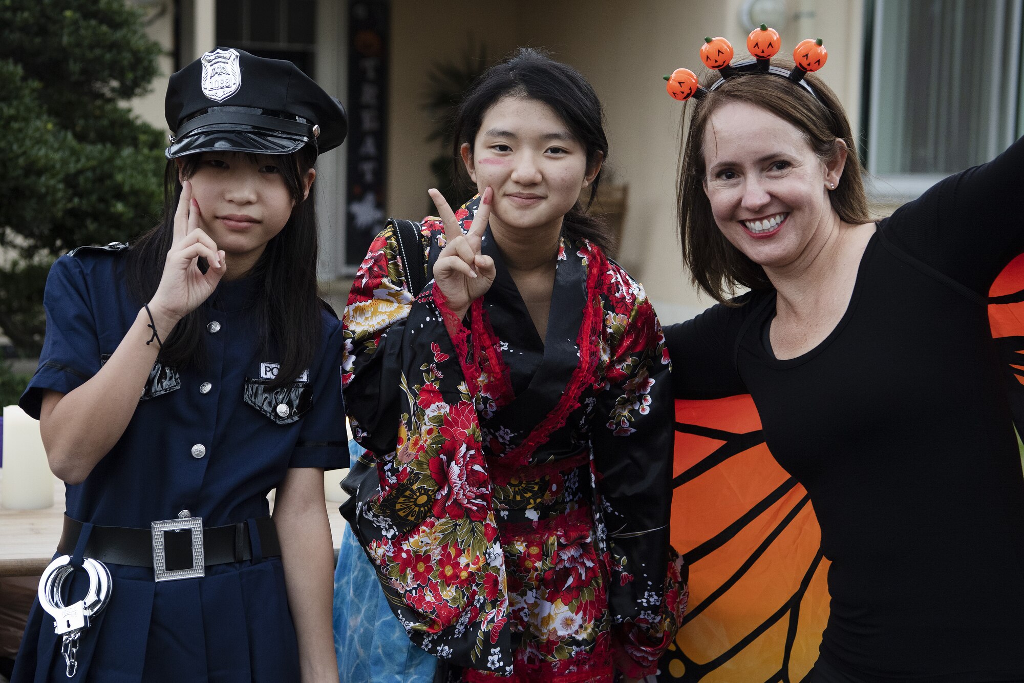 Jennifer Rhyne, Fujimi Elementary School alternate contract English teacher, right, poses for a photo with her students Rin Imai, center, and Kao Nishibe during trick-or-treating at Yokota Air Base, Japan, Oct. 29, 2022. This year, members of the base were able to sponsor up to ten visitors onto base for trick-or-treating. Activities like trick-or-treating give Yokota personnel, families, and friends on and off base an opportunity to celebrate the holiday, enjoy an evening of Halloween activities, and strengthen ties between the U.S. and Japan. (U.S. Air Force photo by Tech. Sgt. Christopher Hubenthal)