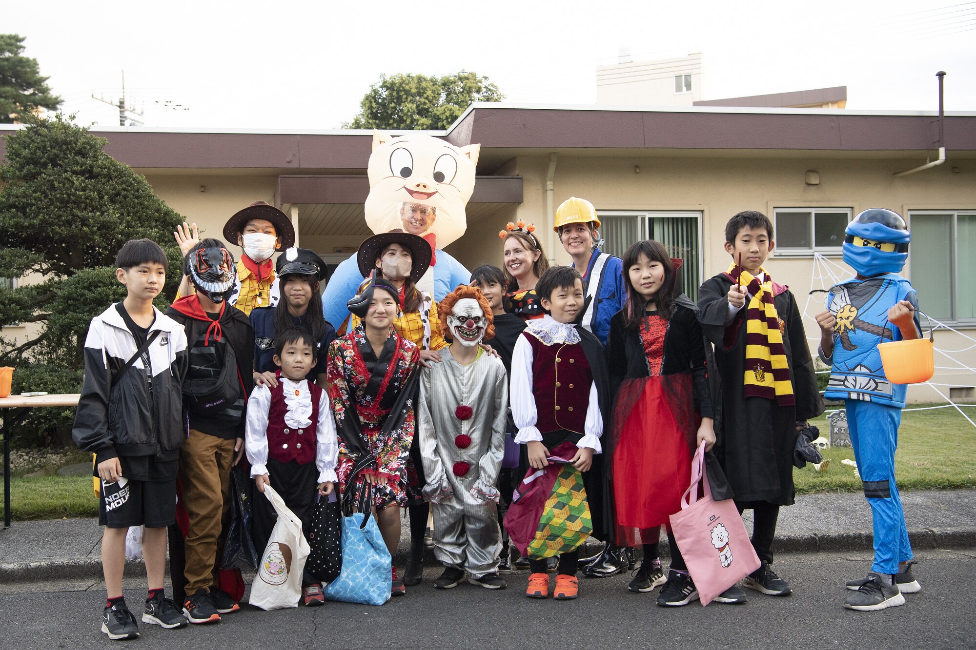 Members of the 374th Airlift Wing and Japanese community pose for a photo during trick-or-treating at Yokota Air Base, Japan, Oct. 29, 2022. This year, members of the base were able to sponsor up to ten visitors onto base for trick-or-treating. Activities like trick-or-treating help build mutual understanding of the distinctive cultures of the U.S. and Japan, deepen friendships, and further strengthen the critical relationship Yokota has with its surrounding communities. (U.S. Air Force photo by Tech. Sgt. Christopher Hubenthal)
