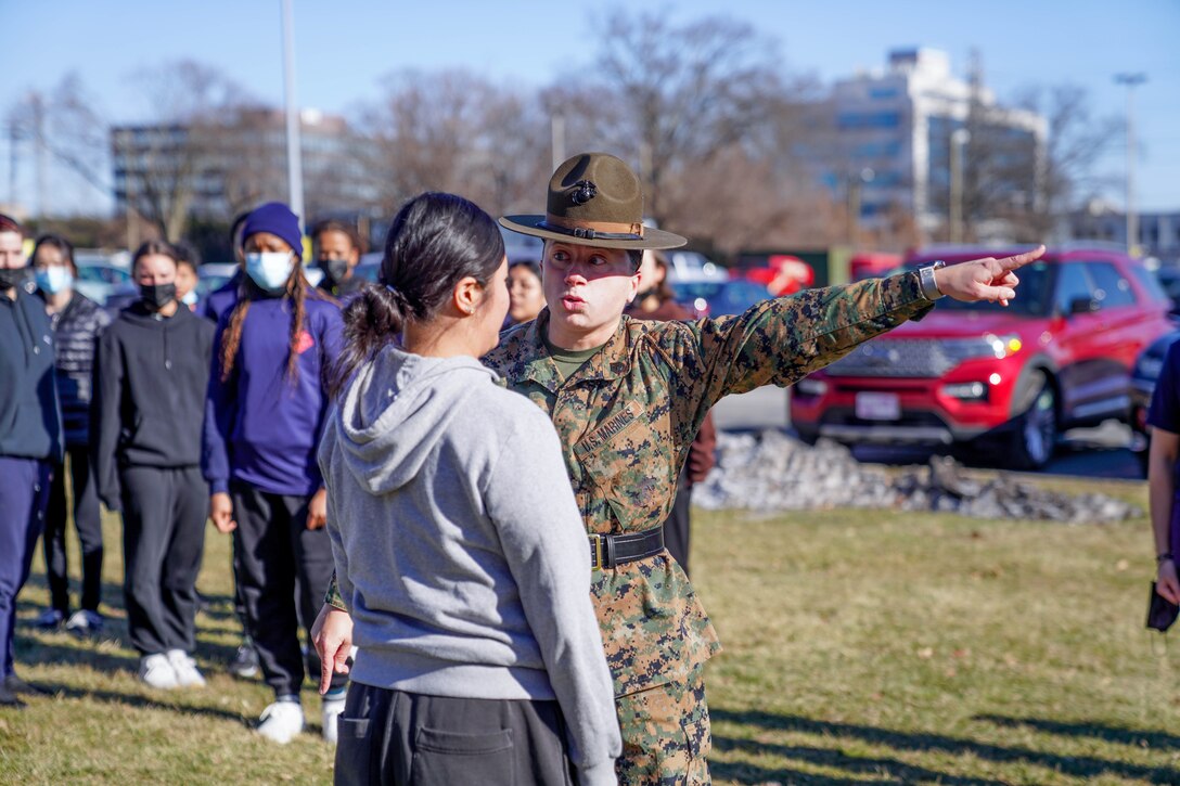 U.S. Marine Corps Staff Sgt. Lily Banhegyesi, a drill master with Marine Corps Recruit Depot Parris Island, South Carolina, corrects a future Marine during a pool function at Recruiting Station New York in Garden City, New York, Jan. 22, 2022. Banhegyesi, a native of Syosset, Long Island, New York, attended the event to assist future Marines in mental and physical preparation for Marine Corps Recruit Training. (U.S. Marine Corps photo by Sgt. Tia Carr)